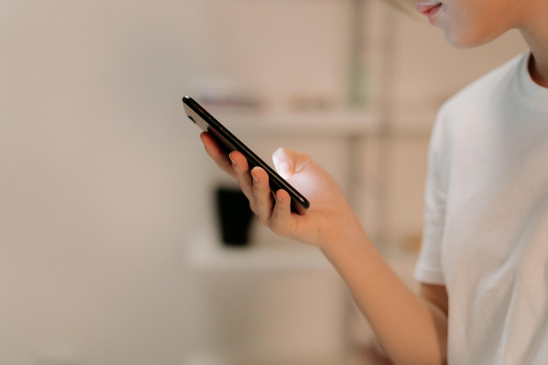 Personne remplissant un formulaire de contact sur smartphone, étape clé d'un site web qui génère des demandes