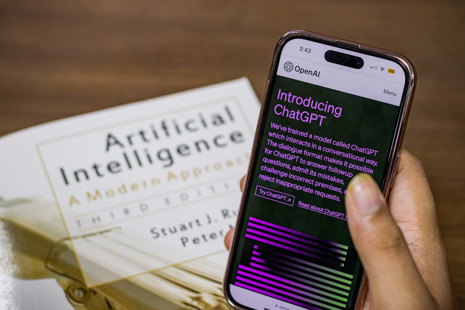 Smartphone affichant ChatGPT au-dessus d'un livre sur l'intelligence artificielle
