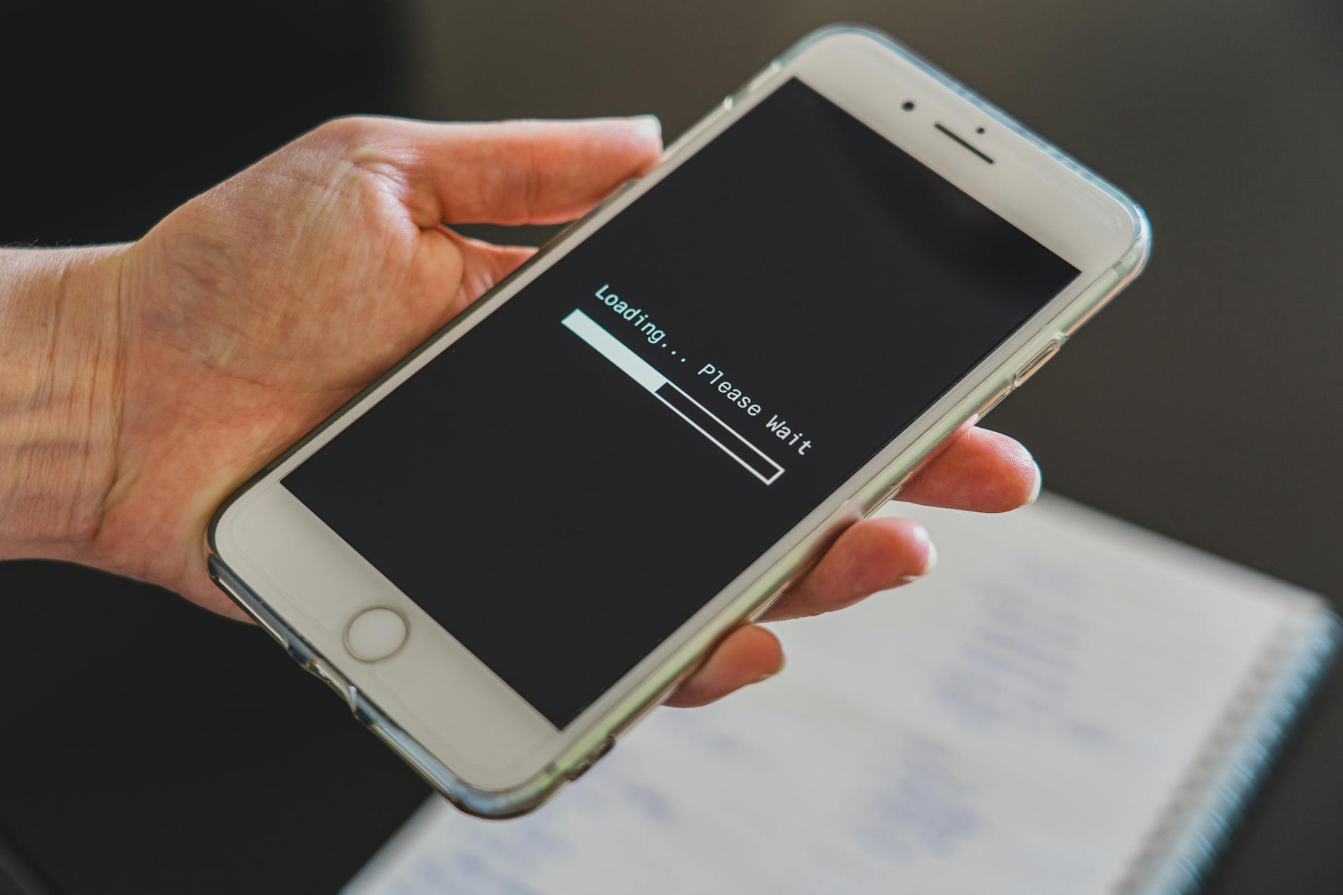 Smartphone affichant un écran de chargement, illustrant l'impact des images sur la vitesse du site mobile