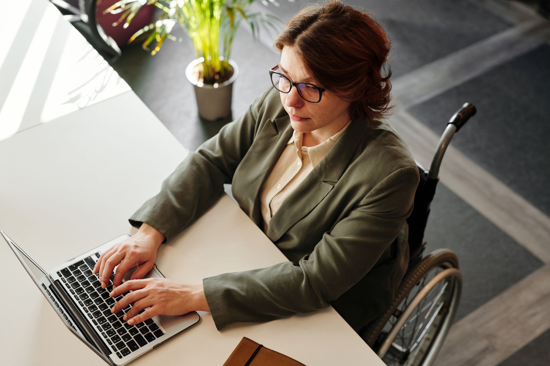 Personne en fauteuil roulant utilisant un ordinateur, illustration de l'accessibilité numérique site web
